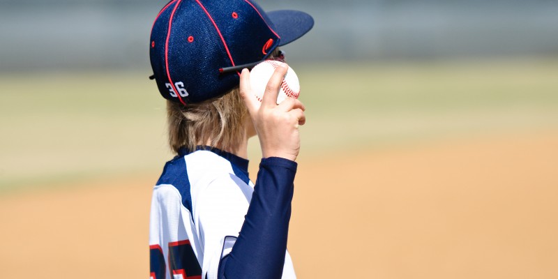 little league baseball player holding a ball